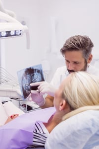 Dentist showing x-ray to the patient in clinic Zahnarzt in Lörrach zeigt Patientin Röntgenbild zur Weisheitszahn OP Beratung