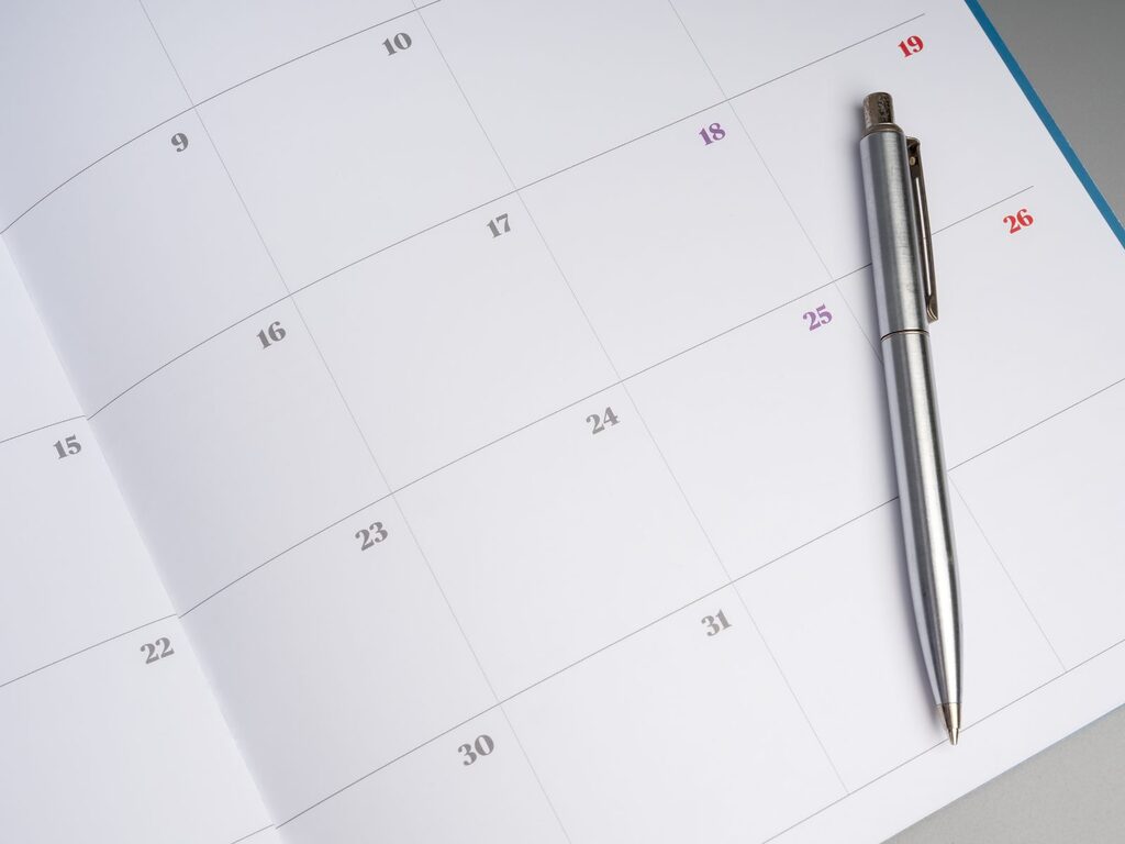Kalender für die Terminplanung Monatskalender mit Kugelschreiber: Schweizer Patienten planen eine Zahnbehandlung in Deutschland oft über mehrere Termine